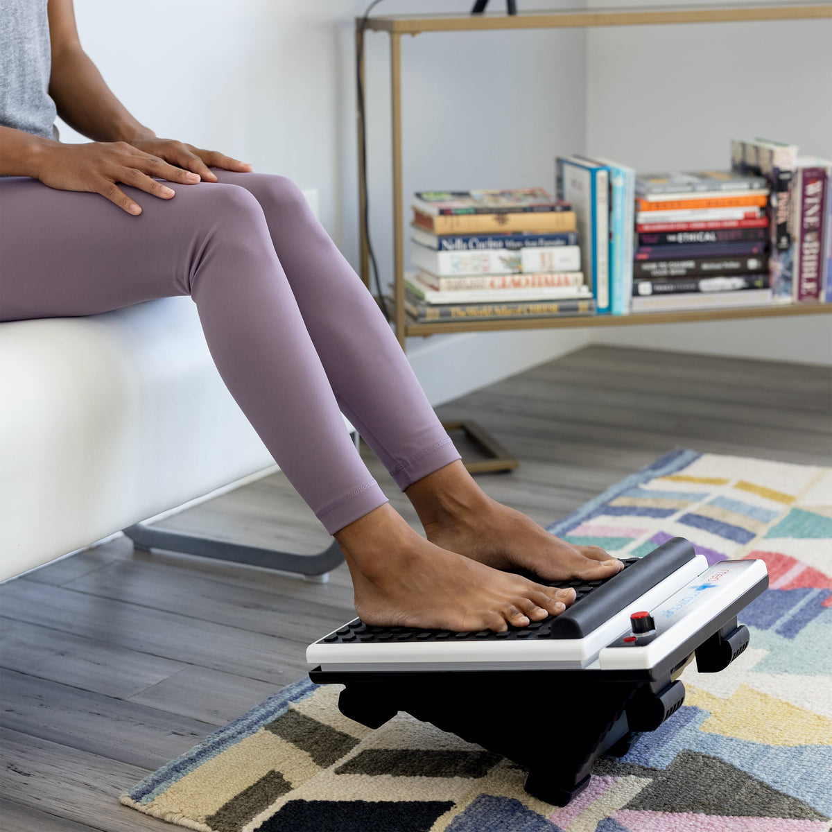 Bare feet on MedMassager foot massager in modern living room, providing therapeutic relief and relaxation.
